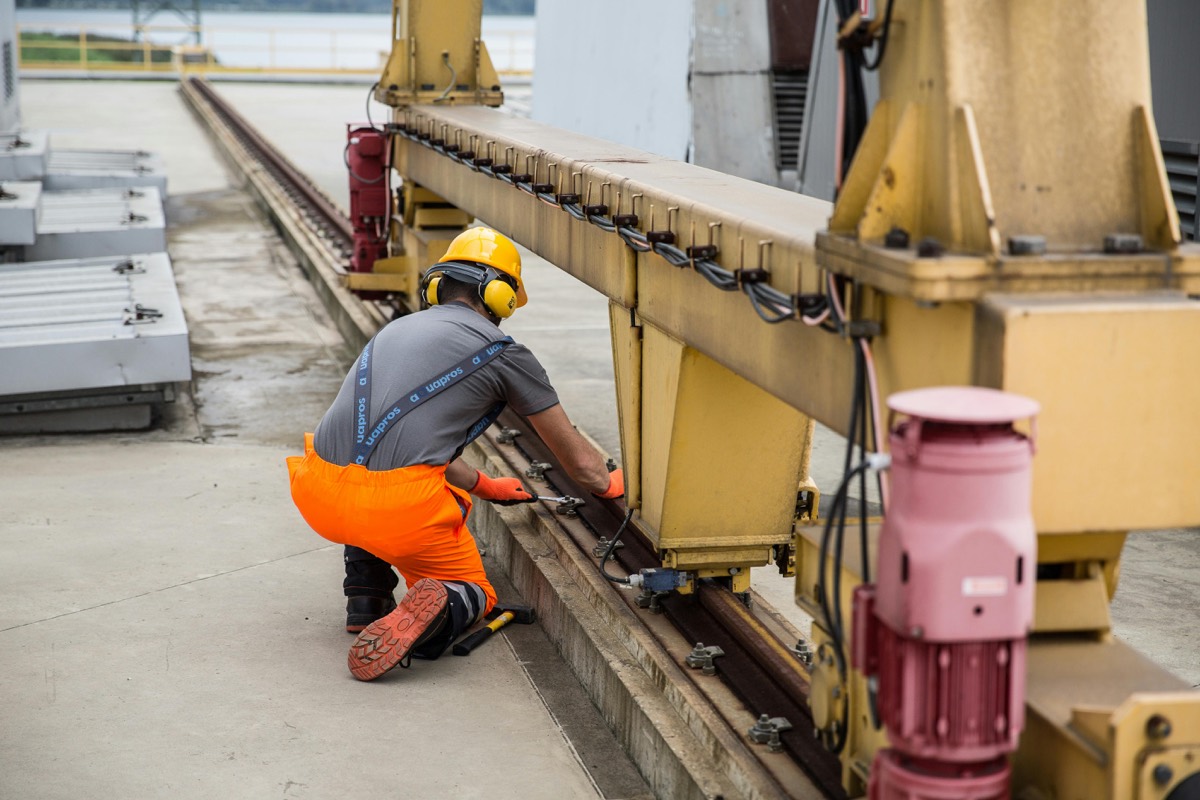 Engineer in hi-vis servicing industrial plant machinery, the kind of planned air compressor servicing Airmech carries out on site.