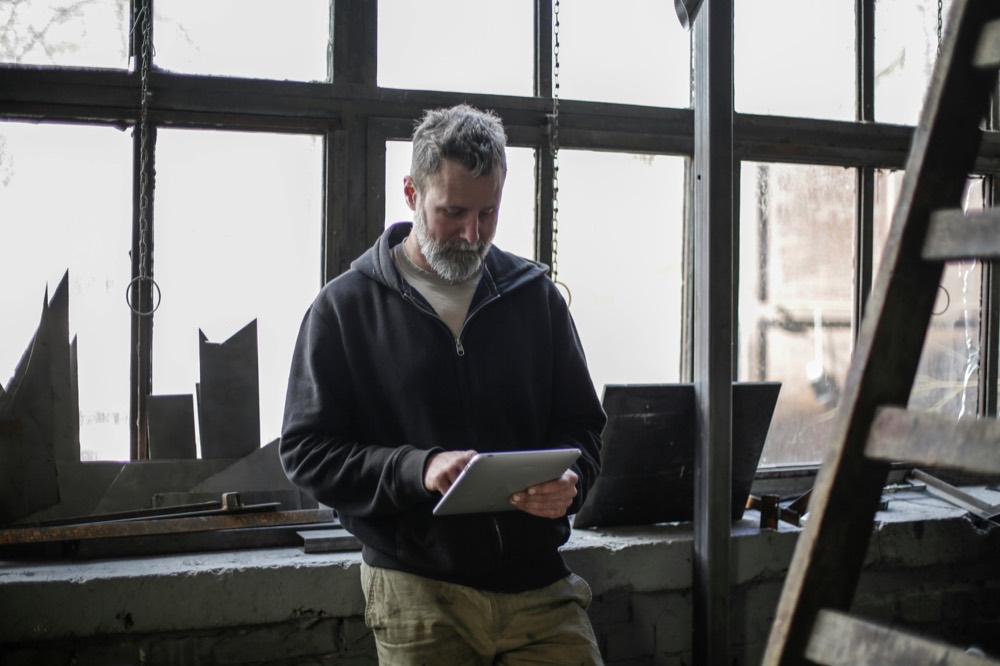 Service engineer logging a job on a tablet, reflecting Airmech's digital service records and 48-hour photo reports.